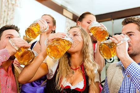 在巴伐利亚酒吧喝啤酒的人餐厅少女装口渴庆典皮裤女士派对男人成人微笑图片