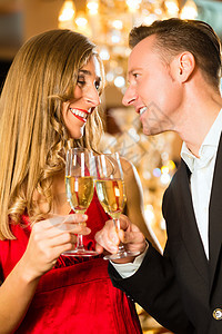 男人和女人在餐馆里喝香槟晚餐夫妻酒精玻璃眼镜庆典微笑套装枝形女士图片