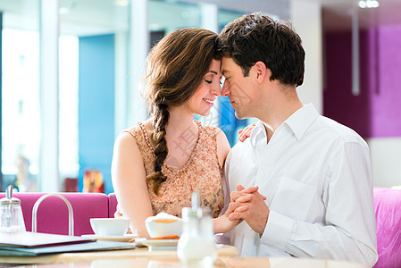 年轻的一对小夫妇咖啡馆拥抱和亲吻已婚闲暇夫妻女士饮料女孩享受男人接吻时间图片