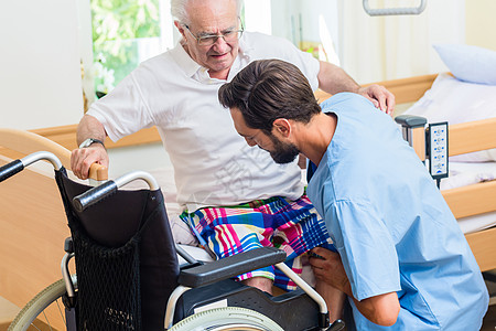 老人睡觉老年护理护士帮助老年人从轮椅到床上睡觉退休服务社会医院老人养老院休息室照顾者职员诊所背景