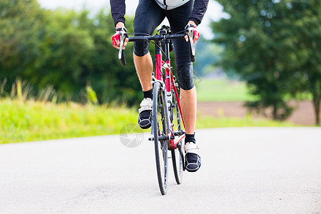 赛车自行车骑脚踏上自行车轨道的Cyclist男人活动旅行车轮紧身衣爱好踏板训练运动服旅游图片