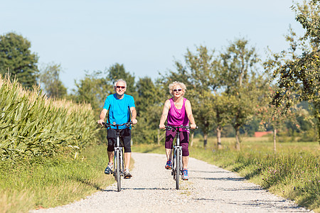 在公园骑自行车期间享受退休休假的在业老年夫妇 参加图片