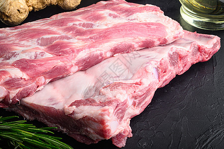 原未烹制的猪排 配有原料的新鲜肉 黑石背景和文本复制空间图片