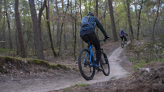男人骑着山车 在春林中 靠近荷兰的乌勒支头盔运动成人行动竞赛运动员冒险骑术活动女士图片