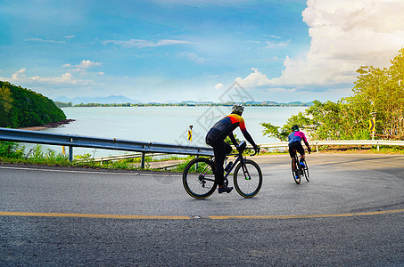 空的空间 夏季在户外头盔骑自行车的男性 骑自行车者自行车速度赛跑活动在山路上 上面是背景中的大海和天空 骑自行车的人的水平照片图片