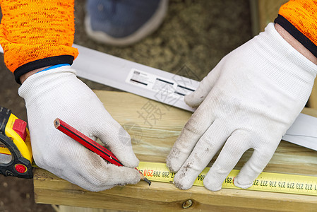 diy 木匠在一块木头上做标记 木匠的手戴着白手套和用于精确工作的工具维修男人材料测量店铺工匠职业仪表木板承包商图片