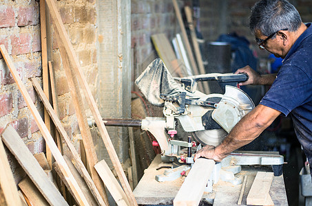 用于将板切割到专业木匠 修理和施工工具手中的圆锯木制品木板刀刃危险工人作坊工匠房子木材手套图片