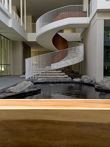 带有螺旋楼梯背景的木桌脚步圆形金属圆圈曲线建筑艺术图片