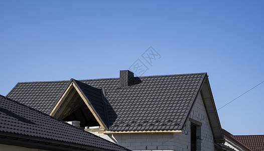 安装在现代房屋上的棕色波纹金属型材屋顶 波纹板屋顶 金属型材波浪形屋顶 现代屋顶由金属制成 金属屋面窗户覆盖物聚合物建造瓦楞山墙图片