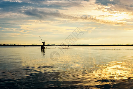 船上的渔民在泰国日出时使用渔网死水风景天空地平线钓鱼阳光日落民间农村场景图片