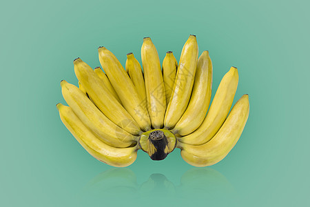 一群黄色成熟的香蕉 在绿色颜色背景上被隔离图片