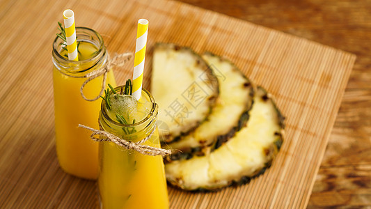 新制菠萝果汁 冰装在小玻璃瓶里 在木本底饮料小吃玻璃橙子食物热带茶点蔬菜酸奶覆盆子图片