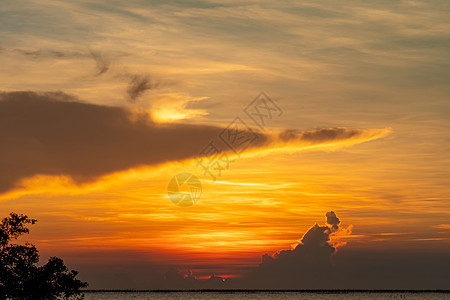 在热带海的美丽的日落天空 金色的夕阳天空 在海上的天际线 自然之美 热带海滩景观 日落天空的风景 天空上一层红色和橙色的云图片