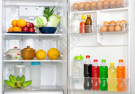 看着冰箱 盖子打开了很多新鲜食物和饮料在里面的冰箱里喝图片