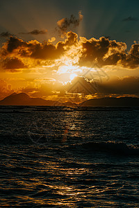 云层与海洋上一些岛屿之间的巨大日落 在海边橙子太阳旅游海景海岸假期反射地平线晴天海浪图片