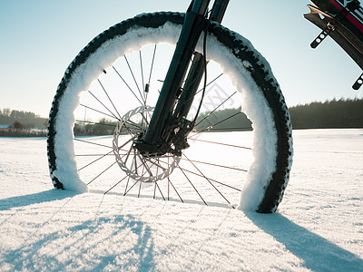 白色雪上紧靠自行车轮的白雪车轮 在极端冬季条件下骑自行车图片