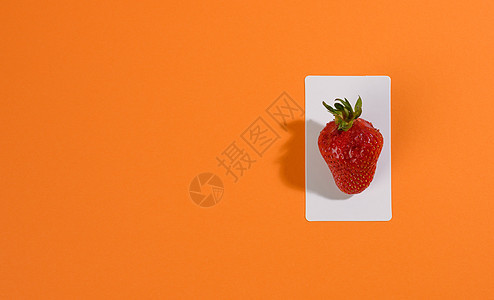 橙色背景的红成熟草莓图片