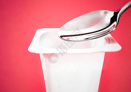 红底面的酸果杯和银勺子 含酸奶霜的白色塑料容器 用于健康饮食和营养平衡的新鲜奶制品食物产品生物乳糖饮食奶油杯子牛奶小吃营养图片