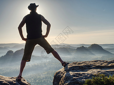 牛仔风格的登山者 在公园悬崖上的男人 正在监视范围旅游风景生活方式天空危险运动装沉思自由休闲山峰图片