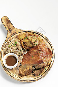 传统的德国猪肉关节 配有酸菜和土豆乡村食物白色餐厅木头猪蹄美食托盘推介会图片