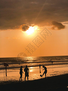 日落剪影玩沙滩足球踢足球伊帕内玛海滩里约热内卢巴西图片