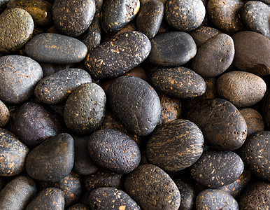 干圆灰河石背景的质地棕色自然岩石圆形灰色卵石材料黑色海绵状图片
