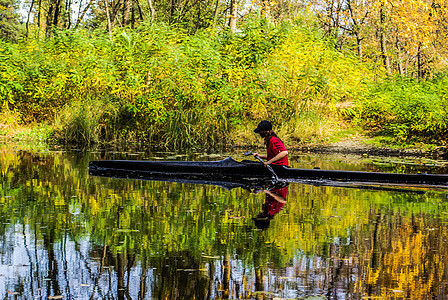 穿独木舟的年轻女子与桨在雨林中河上游泳女孩日落女士乐趣运动员划桨闲暇皮艇冒险假期图片