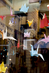五颜六色的纸折纸鸟绑在绳子上创造力起重机艺术航班鸽子鸟类翅膀背景图片