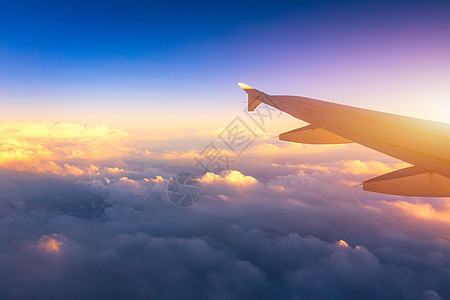 飞行和旅行 在日落时间从机翼上的飞机窗口查看 在地球和云层下的飞机机翼 在天空中飞行 看着飞行中的飞机机翼商业航班运输喷射航空公图片