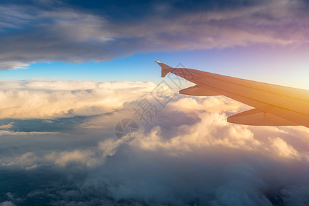 飞行和旅行 在日落时间从机翼上的飞机窗口查看 在地球和云层下的飞机机翼 在天空中飞行 看着飞行中的飞机机翼地平线方式空气旅游货物图片