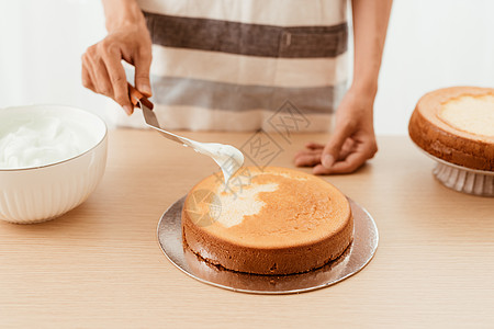 糕点厨师在海绵蛋糕上加奶油 做蛋糕的过程女士馅饼食物厨房桌子糖果商烹饪女性面包师食谱图片