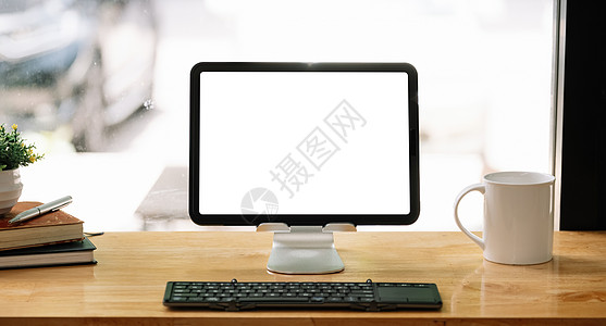木制桌子上有空白屏幕板的便携工作空间 咖啡店有复制空间和装饰品网络展示监视器办公室屏幕技术互联网电脑手机笔记本图片