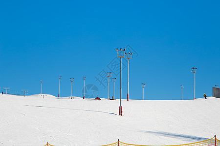 滑雪度假胜地 雪坡 有塔塔和泛光灯的足迹旅游日落娱乐蓝色山脉绳索运动假期跑步目的地图片