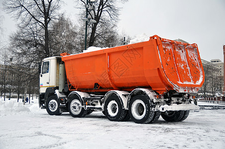 从城市街道上清除雪雪的车载大量运输工具暴风雪城市红色打扫机械降雪工业车辆运输机器图片