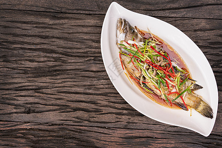 木制桌上有酱油的蒸汽鱼盘子烹饪美食海鲜海鱼大豆桌子饮食厨房餐厅图片