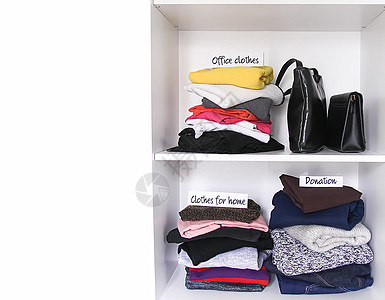 简易衣柜家庭衣橱里的不同衣服 上面有纸条 小空间组织 垂直存储背景