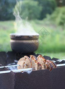 面包和肉放在烤箱上 旧锅子加香草茶放在烤箱上炙烤母亲幸福篮子童年桌子树叶后院木炭果汁图片