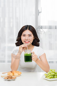 年轻的年青女性享受健康的素食清凉 体重减肥和戒毒女士绿色厨房排毒饮料饮食冰沙果汁蔬菜水果图片