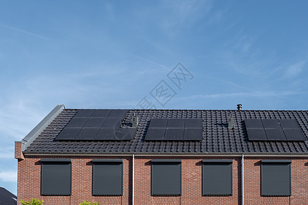 在阳光明媚的天空下 屋顶上附有太阳能电池板的新建房屋特写带有黑色太阳能电池板的新建筑 翻译 太阳能电池板 太阳能活力晴天住宅技术图片