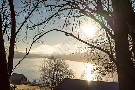 在寒冷而宁静的初秋早晨 在地平线上群山环绕的乡村 湖面和乡村景观的宁静日出图片
