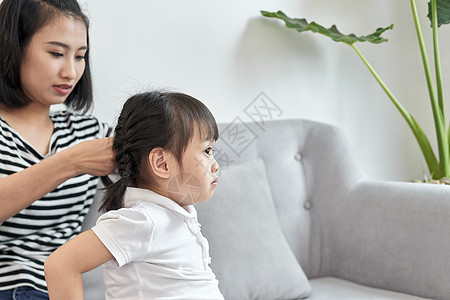 母亲是她女儿的毛发女士微笑女孩母性成人孩子发型女性家庭理发图片