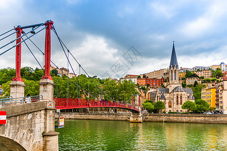 位于法国罗内里昂的Saone河和圣乔治教堂上的脚桥图片
