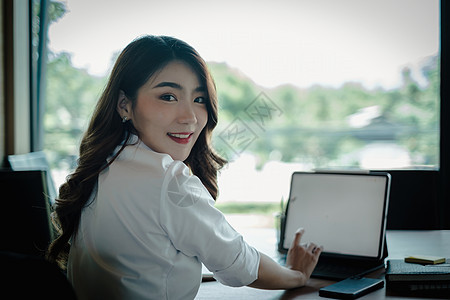 办公室中的商业妇女 办公桌上有膝上型计算机会议中年人互联网微笑商务女士电脑专注人士经理图片