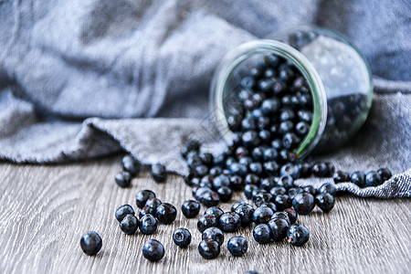 有选择性的焦点 新鲜蓝莓 从玻璃罐里溢出 在木质背景上 果汁丰盛的野生森林浆果甜点水果饮食花园覆盆子农业营养静物收成桌布图片