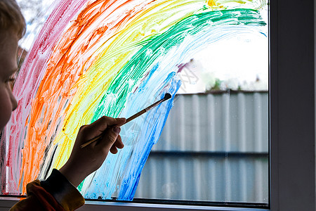 小男孩在窗户上画彩虹 隔绝时坐在家里 看着窗外的风景 笑声手指艺术家艺术童年保健男生幼儿园学校服务家庭图片
