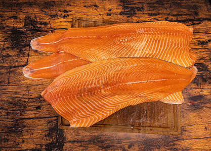 木板上大块生鲑鱼片盘子美食饮食产品红色牛扒市场海鲜鱼片食物图片