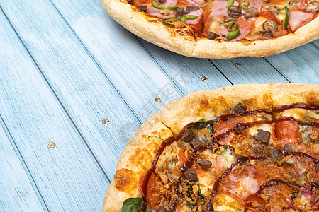 两件不同的美味大比萨饼 蓝木木背景小吃烤箱木板食品加工火腿洋葱静物脆皮蓝色厨房图片