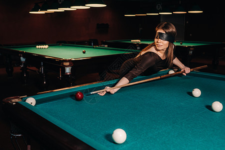 在台球俱乐部里 一个戴着眼罩 手里拿着球杆的女孩 俄罗斯台球眼睛台球桌爱好绿盖枕头玩家桌子游戏裙子口袋图片