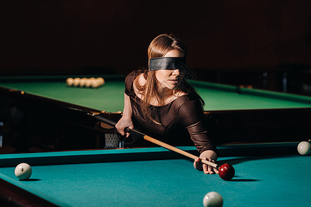 在台球俱乐部里 一个戴着眼罩 手里拿着球杆的女孩 俄罗斯台球角落枕头线索玩家娱乐眼睛游戏爱好裙子口袋图片