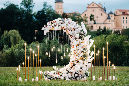 在奈斯维日城堡附近的街上举行婚礼仪式 以月亮的形式献出鲜花来装饰婚姻接待风格安装文化国家奢华报名玻璃背景图片